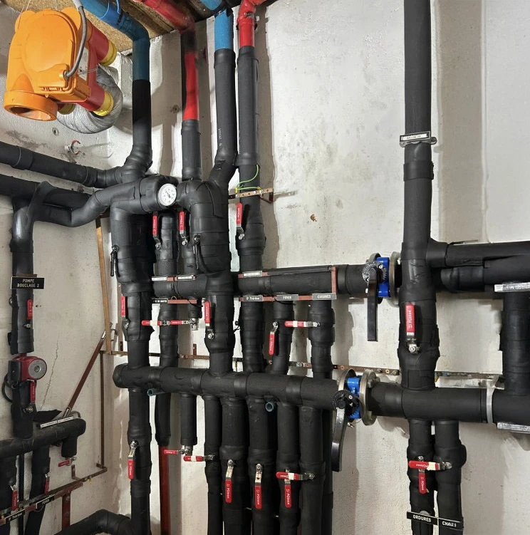 Salle technique intérieure avec installation de plomberie et chauffage