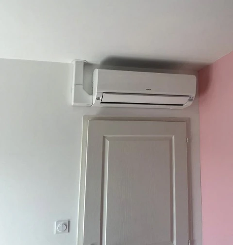 Intérieur résidentiel avec climatiseur mural installé au-dessus d'une porte