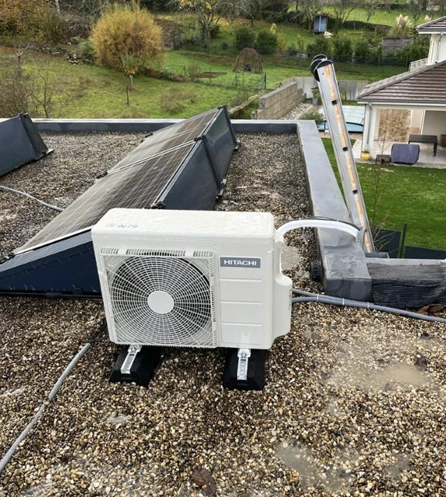 Deux unités extérieures de climatisation installées contre un mur en pierre naturelle d'un bâtiment ancien
